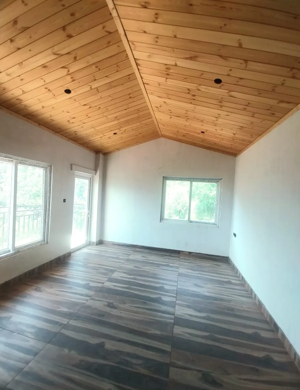 Top-floor room with sloping pine-wood ceiling
